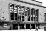Auch die Fassade des Düsseldorfer Hauptbahnhofs aus dem Jahr 1936 ist sechs Jahre nach Kriegsende noch von Einschusslöchern der Tiefflieger übersät. Die äußere Gestalt der Backsteinfassade mit den gliedernden Natursteinelementen blieb aber erhalten und kennzeichnet noch heute den Eingangsbereich zum Düsseldorfer Hbf vom Konrad-Adenauer-Platz her. (16.07.1951) <i>Foto: BD Wuppertal (Säuberlich)</i>