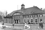Porträt des zweiten Steinbecker Empfangsgebäudes, das das Gebäude aus der Anfangszeit der Düsseldorf-Elberfelder Eisenbahngesellschaft ersetzte und um 1878 im Stil öffentlicher Bauten in Preußen erstellt wurde. Eine Architektur zwischen Monumentalbau (Fassade der Eingangshalle mit klobigen Segmentgiebel) und Gartenstadt-Villa (mit Walmdach und Festerläden im Obergeschoß). Es diente zunächst sogar dem überregionalem Personenverkehr, bis im Lauf der nächsten Jahre die Aufgaben zum Döppersberger Bahnhof (Wuppertal-Elberfeld) abgegeben wurden. Mit Errichtung des Bauwerkes war auch eine Veränderung der Bahnanlagen verbunden, der wirklich große Umbau (Verlegung der Betriebswerkstätte, neuer Vorbahnhof mit Gütertrasse zum Bahnhof Zoo) erfolgte erst nach 1910 im Rahmen des viergleisigen Ausbaus der Tallinie (fertig 1914). Damit das Gelände vor dem Bahnhof belebter wirkte, hat der Fotograf mit Retusche bei den Personen etwas tölpelhaft nachgeholfen. (1900) <i>Foto: RVM</i>