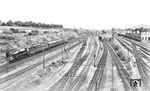 03 012 (Bw Hannover) fährt mit FD 226 nach Köln durch Wuppertal-Vohwinkel. Die Perspektive verdeutlicht gut die Streckenentwicklung in Höhe des Westbereichs des Vohwinkler Personenbahnhofes. In der Bildmitte im Hintergrund ist noch schwach das Empfangsgebäude mit dem Turm erkennbar. Vorbei an abgestellten Reisezugwagen rollt der Zug ganz links auf der Fernstrecke nach Köln/Düsseldorf, davor verläuft die “Korkenzieher”-Trasse nach Solingen. In der Bildmitte die umfangreiche Gleisentwicklung der Ein- und Ausfahrten zum Vohwinkler Verschiebebahnhof mit der Überführung zur Rheinischen Strecke und der Unterführung zur Essener Strecke. Rechter Hand gibt es Güteranlagen zu sehen und ganz rechts das alte Empfangsgebäude vom ehemaligen Personenbahnhof vor 1908.  (1932) <i>Foto: DLA Darmstadt (Bellingrodt)</i>