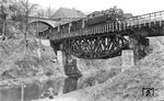 Wo einst Spaziergänger an der Wupper entlang flanierten, ist seit Anfang der 1950er Jahre der Beyenburger See aufgestaut und lädt zu anderen Freizeitaktivitäten ein. Auch ist die Gegend durch große Straßenumbauten ab Mitte der 1960er Jahre kaum wieder zu erkennen. Eigentlich gibt es so nur noch die Fischbauchträgerbrücke. Anno 1935 war das alles anders und die Eisenbahn war das zentrale Verkehrsmittel für Reisen und den Gütertransport. Über die Brücke rumpelt gerade 86 202 mit dem Nahgüterzug 5385 nach Radevormwald. Die Lok ist noch nicht allzu lange im Einsatz und gehört zu einer Serie von Neuanlieferungen der Baureihe an das Bw Steinbeck. 86 202 zählte ab 15.12.1934 zum dortigen Lokbestand. Links oben parkt übrigens der fahrbare Untersatz von Carl Bellingrodt. (20.04.1935) <i>Foto: DLA Darmstadt (Bellingrodt)</i>