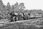 Die zum Bw Dresden-Friedrichstadt gehörende 50 2378 ist in der Dresdener Heide bei Dresden-Klotzsche auf dem Weg nach Dresden. Die Lok ist mit dem Kessel einer ehemaligen Kondens-52er ausgerüstet, erkennbar am Oberflächenvorwärmer und der kurzen Esse. Als ehemalige ÜK-Lok (siehe Bild-Nr. 70549) ist sie am Scheibenlaufradsatz zu erkennen. Nachträglich wurde eine Schürze angebaut. Die oben auf der Rauchkammer montierte obere Leuchte des Dreilichtspitzensignals ist ebenfalls 'Marke Eigenbau'. Der Gepäckwagen hinter der Lok ist ein alter Sachse (Pw3i Sa.), der modern wirkende 4-achsige Abteilwagen dahinter ist französischer Herkunft, die dann folgenden 4-achsigen Abteilwagen mit Flachdach sind sächsischer Bauart. (22.06.1966) <i>Foto: Will A. Reed</i>