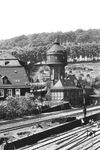 Blick auf den Wasserturm des Bw Steinbeck, ab 1. Juli 1950 Bw Wuppertal-Steinbeck, dessen eigentliches Areal sich links außerhalb des Bildes befindet. Obwohl Steinbeck nach dem Krieg ein reines Diesel- und VT-Bw wurde, blieb der Wasserturm noch bis in die 1960er Jahre stehen. An den Ausfahrgleisen vom Bahnhof bzw. an der Trasse zum Überführungsbauwerk der Güterbahn wird gerade gewerkelt. (1931) <i>Foto: RBD Wuppertal (Eckler)</i>