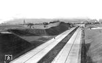 Über die neuerbaute Reichsautobahn Köln—Düsseldorf—Duisburg (heutige BAB A 3), die am 21. Mai 1936 eröffnet wurde, führte auch die Steilstrecke von Erkrath nach Hochdahl. Während einige Zeitgenossen die neue Schnellstraße schon vor der Eröffnung als Rennstrecke ausprobieren, fährt im Hintergrund angeblich gerade 58 2037 mit Schubunterstützung von den (nicht mehr sichtbaren) 94 1647 und 1648 über die Steilrampe. Bis Ende 1936 betrug die Streckenlänge der Reichsautobahnen übrigens 1087 km (im Jahr 2023: 13.200 km). (03.1936) <i>Foto: DLA Darmstadt (Bellingrodt)</i>