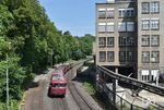 Von der Brücke der Finkensiefstraße in Stolberg-Altstadt geht der Blick auf eine 6-teilige Schienenbuseinheit der Vulkaneifelbahn, die auf der Bahnstrecke Stolberg - Walheim aus Breinig kommend in den Bahnhof einfährt. Das Gebäude rechts erinnert auf den ersten Blick an Fabrikgebäude in der DDR. Es handelt sich um einen Teil der Dalli-Werke, die Waschmittel produzieren. Der frühere Gleisanschluss rechts zum Tor ist auch noch zu erahnen. (26.05.2018) <i>Foto: Ralf Opalka</i>