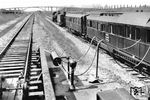 Der Brückenmesszug des Reichsbahnzentralamtes Berlin bei einer Schweißnahtuntersuchung. Als Zuglok dient eine pr. S 10 (Baureihe 17). Zitat aus "Die Reichsbahn" (5/1931): "Auch auf dem Gebiet des Eisenbahnbrückenbaues ist die Deutsche Reichsbahn in diesem Jahre zu praktischen Ausführungen geschweißter Stahlbauten übergegangen und hat damit die Führung in der Anwendung des Schweißverfahrens im Eisenbahnbrückenbau übernommen. Die jetzt in der Hauptbahnstrecke Münster-Osnabrück liegende ganz geschweißte, 10 m weit gestützte Brücke mit vollwandigen Hauptträgern und versenkter Fahrbahn ist die erste und vorläufig einzige geschweißte eigentliche Eisenbahnbrücke der Welt. Bevor die Brücke in die genannte Hauptstrecke eingebaut wurde, war sie vorübergehend in der noch nicht im Betriebe befindlichen Umgehungsbahn bei Münster aufgestellt worden. Hier wurde sie ganz eingehenden Untersuchungen und Erprobungen unterworfen, um ihre unbedingte Sicherheit für den Eisenbahnbetrieb festzustellen. Die Brücke wurde Röntgenographischen Untersuchungen, statischen (Dauerbelastung) und dynamischen Versuchen (mit der Schwingungsmaschine) sowie der Betriebsbelastung unterworfen. Alle Versuche verliefen erfolgreich und sie wurde eingebaut. Andere Bilder, der von der Gutehoffnungshütte gebauten Brücke zeigen, dass sie für die Versuche nur ein wenig über dem Erdboden montiert worden ist. Die seitlich herausschauenden Betonbalken liefen unter der Brücke durch. Auch sind die Widerlager extra für den Versuch gebaut worden. Es war quasi die Erprobung auf der grünen Wiese. Im Rücken des Fotografen Ihres Bildes stand übrigens die Schwingungsmaschine, die ihre Energie aus einem Wittfeld-Akku bezog."  (1931) <i>Foto: RVM</i>