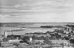 Der Rügendamm war die erste feste Verbindung zwischen Stralsund und der Insel Rügen. Über ihn führten sowohl die alte Reichsstraße 96, die Bahnstrecke Stralsund—Saßnitz als auch ein kombinierter Fuß- und Radweg. Die Hauptfahrrinne im Ziegelgraben wurde mit einer Klappbrücke von 25 m Breite überquert (ganz rechts), weiter entstand ein aufgeschütteter Teil (Bildmitte) und eine 540 m lange Brücke von der Insel Dänholm nach Rügen mit 10 Öffnungen von je 54 m Breite (links). Der Damm war 2.540 m lang und hat eine ca. 15 m breite Dammkrone, die die Straße, den Bahnkörper und einen Fuß- und Radweg aufnahmen. 1936 wurde der Rügendamm für den Eisenbahnverkehr geöffnet, 1937 für den Straßenverkehr. Die Ziegelgrabenbrücke öffnete mehrmals täglich, um Schiffen die Durchfahrt zu ermöglichen.  (1937) <i>Foto: RVM</i>