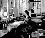 Blick in eine Fahrkartenausgabe, vermutlich im Frankfurter Raum. Das bereits von anderen Bildern bekannte Werbeplakat im Hintergrund, das Frauen für den "kriegswichtigen Einsatz" bei der Reichsbahn gewinnen sollte, war eine direkte Folge des Scheiterns des Blitzkrieges gegen die Sowjetunion, das die NS-Strategen eiskalt erwischte. Der Einsatz an der Ostfront beanspruchte immer größere Ressourcen, daher versuchten das NS-Regime, den Männermangel durch den Einsatz von Frauen wettzumachen. (1942) <i>Foto: RVM (Trost)</i>