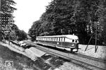 Der als "Fliegender Hamburger" bekannte SVT 877 a/b (Bw Berlin Leb) war der erste Dieselschnelltriebwagen der Deutschen Reichsbahn im planmäßigem Einsatz. Ab 15. Mai 1933 verkehrte der Triebzug planmäßig zwischen Berlin Lehrter Bahnhof und Altona Hauptbahnhof. Für die 286 km lange Strecke benötigte er 138 Minuten, eine Zeit, die erst 64 Jahre später im Juni 1997 von einem ICE-Zug der Deutschen Bahn AG mit 132 Minuten unterboten wurde. Zu seiner Zeit war er weltweit die schnellste Zugverbindung. Als Zeichen seiner Exklusivität wurde er wie die Wagen des „Rheingold-Zuges“ cremefarben und violett lackiert. Walter Hollnagel erwischte ihn auf der Fahrt nach Altona als Nachschuss im Sachsenwald bei Hamburg. (09.06.1933) <i>Foto: Walter Hollnagel</i>