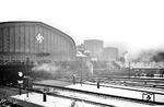 Bei trüben Winterwetter war selbst die bordeauxrote 05 002 vor der Halle des Hamburger Hauptbahnhofs nur noch schemenhaft zu erkennen. Um so erstaunlicher, dass sie es an diesem Tag tatsächlich noch auf 175 km/h bei der Pressefahrt nach Berlin schaffte (vgl. Bild-Nr. 58427), für das Lokpersonal bei solchem Wetter sicherlich kein Vergnügen. (25.02.1936) <i>Foto: Walter Hollnagel</i>