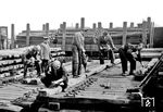 Herstellen von Schwellen in einem unbekannten Werk der Reichsbahn. Für den Fotografen wurden alle Arbeitsschritte dokumentiert, angefangen vom Bohren der Löcher, Einschlagen der Kleineisen für die spätere Schienenbefestigung und das Konservieren mit Teer. Heute sind auf dem Schienennetz allein in Deutschland rund 54 Millionen Bahnschwellen verbaut, die allerdings überwiegend nicht mehr aus Holz bestehen. (1934) <i>Foto: RVM</i>