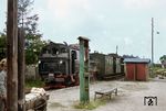 Bevor die 99 593 gegen 10 Uhr mit dem Gmp 8072 nach Glöwen abfährt (u.a. mit dem Gepäckwagen 976-101), ist im Bahnhof Lindenberg noch Stückgut und Gepäck zu verladen. Auch bleibt ein wenig Zeit, die Bahnsteigausstattung zu betrachten. Zu einem Eisenbahnknoten gehört selbstverständlich ein Zugrichtungsanzeiger. Die Schilder des schon in die Jahre gekommenen mechanischen „Hampelmanns“ in Lindenberg waren zuletzt schon ziemlich verrostet. Kleinbahnmäßig waren auch die Sitzbank und der kleine Freiabort mit der Schamwand.  (29.08.1967) <i>Foto: Klaus Kröber (Sammlung Ludger Kenning)</i>