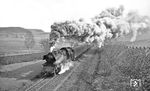 65 1011 mit P 8042 auf anstrengender Bergfahrt auf der Steigung kurz vor Singen/Thüringen. (03.1976) <i>Foto: Burkhard Wollny</i>