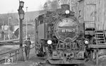 99 1790 bei Pflegearbeiten im Bahnhof Cranzahl. Dieser wurde 1872 zusammen mit der Bahnstrecke Weipert – Annaberg (links im Bild) in Betrieb genommen. Es entstanden Schmalspuranlagen mit Umladehalle, Betriebsmittelüberladerampe und einem einständigen Heizhaus nördlich der bestehenden Normalspuranlagen. Zwar wurde so eine Kreuzung zwischen Schmal- und Normalspur notwendig; bei einer anderen Gleisanordnung (südlich der Normalspuranlagen) hätte allerdings wesentlich mehr Erdreich bewegt werden müssen, und man befürchtete im Winter erhebliche Schneeverwehungen. Letztmalig wurde der Bahnhof 1912 umgebaut. Dabei entstanden auch die heutigen Personenverkehrsanlagen südlich der Normalspurbahn. Seitdem ist der Bahnhof in seiner wesentlichen Form bis heute unverändert geblieben.  (04.1976) <i>Foto: Burkhard Wollny</i>