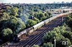 Blick aus einem Haus an der Lüneburger Straße auf 01 0527, die zwischen Bellevue und Lehrter Bahnhof vor D 1333 über die Berliner Stadtbahn rollt. Links grüßt die Kongresshalle, die im Großen Tiergarten 1956/57 entstand. Bis heute sorgt die Kongresshalle für Aufsehen mit ihrem frei hängenden Dach, das sich in einem weiten und hohen Bogen über das Auditorium spannt. Am Vormittag des 21. Mai 1980 stürzte der südliche Teil des Dachrandes während einer Pressekonferenz zu einer Tagung des Rings Deutscher Makler ein. Dabei wurden fünf Menschen verletzt, einer erlag später seinen Verletzungen. Eine gutachterliche Untersuchung ergab, dass die Ursache des Einsturzes sowohl in einer mangelhaften Planung des Daches als auch in einer mangelhaften Bauausführung und damit letztlich in einem Statikfehler lag. (07.1976) <i>Foto: Karsten Risch</i>