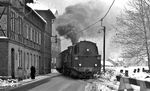95 0045 passiert mit P 18003 (Saalfeld - Sonneberg) die Steinacher Straße in Sonneberg Nord. Die Zugführerin, die die Bahnübergangssicherung per Fahne übernommen hatte, wird gleich wieder in den Zug einsteigen. (01.1978) <i>Foto: Burkhard Wollny</i>