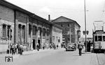 Das Empfangsgebäude des ersten Bahnhofs Ludwigshafen von 1847 war ein zweigeschossiger Bau mit Uhrentürmchen und eingeschossigen Seitenflügeln. Mit der Eröffnung der Strecken nach Worms (15. Juni 1853) und über die Rheinbrücke nach Mannheim (25. Februar 1867) wurden beidseits des ursprünglichen Bahnhofs dreigeschossige Flügelbauten mit wesentlich höherem Bauvolumen ergänzt. Dem so entstandenen Gebäudeensemble des Kopfbahnhofs wurden ab 1910 noch zweigeschossige Zwischenbauten mit vorgesetzten Arkaden hinzugefügt. Nach den Zerstörungen im Zweiten Weltkrieg präsentiert sich der Hauptbahnhof mit dem, was übrig geblieben ist, als provisorischer Flachbau. Dennoch hat mit Straßenbahn und Autoverkehr wieder eine gewisse Normalität eingesetzt. (1951) <i>Foto: BD Mainz, Slg. W. Löckel</i>
