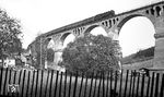 Eine etwas andere Perspektive auf das Piesau-Viadukt mit dem P 18005, der von Lichte Ost nach Lichte unterwegs ist. Der Viadukt aus Stampfbeton ohne Stahl wurde zwischen 1911 und 1913 erbaut und verläuft in einer Höhe von 34 m mit 10 Bögen über das Tal der Piesau. (07.1977) <i>Foto: Burkhard Wollny</i>