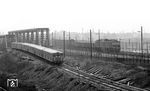 Ein S-Bahnzug aus Richtung Wollankstraße an den Grenzanlagen in der Nähe des beim Bau der Berliner Mauer am 13. August 1961 geschlossen S-Bahnhof Bornholmer Straße überholt einen Güterzug mit 130 034, der auf der Ostseite unterwegs ist. (30.03.1972) <i>Foto: Burkhard Wollny</i>