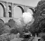 38 1182 mit einem Sonderzug bei Barthmühle auf dem Weg nach Plauen. Darüber führt die Elstertalbrücke mit der Bahnstrecke Hof - Plauen. (23.09.1983) <i>Foto: Joachim Schmidt</i>