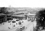 Der erste Heidelberger Hauptbahnhof entstand 1840 als Kopfbahnhof nahe der Heidelberger Altstadt. Städtebauliche Probleme durch den teilweisen Ausbau zum Durchgangsbahnhof 1862 und fehlende Erweiterungsmöglichkeiten führten Anfang des 20. Jahrhunderts zu der Entscheidung, den Bahnhof um gut einen Kilometer nach Westen zu verlegen und dort als Durchgangsbahnhof neu zu bauen. Unterbrochen von beiden Weltkriegen dauerte die Verlegung der Heidelberger Bahnanlagen über 50 Jahre - da sage nochmal einer was gegen den BER... Das Bild zeigt den Blick auf den Hauptbahnhof Anfang der 1930er Jahre. Zwischen den beiden Empfangsgebäuden von 1840 (badischer Teil) und 1848 (Main-Neckar-Eisenbahn) wurde der hier sichtbare Arkadengang errichtet, in dessen Mitte sich eine Toreinfahrt als Haupteingang zum Bahnhof befand. (1930) <i>Foto: RVM</i>