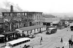 Das zerstörte Empfangsgebäude von Kaiserslautern Hbf Ende der 1940er Jahre. Das erste Empfangsgebäude erhielt der Bahnhof zum Zeitpunkt der Eröffnung der Ludwigsbahn im Jahr 1848. Weil es sich in Bezug auf das Verkehrsaufkommen bereits drei Jahrzehnte später als zu klein erwies, wurde es 1879 abgerissen. Das zweite Gebäude des Bahnhofs (Foto) fiel deutlich größer aus. Durch die Zerstörungen im Zweiten Weltkrieg wurde es so stark in Mitleidenschaft gezogen, dass es in der Nachkriegszeit abgerissen wurde. Beim Bau des dritten Empfangsgebäudes Anfang der 1950er Jahre wurde die Notwendigkeit für zwei neue durchgehende Betriebsgleise und drei neue Bahnsteigkanten berücksichtigt. Das war nur zu verwirklichen, indem die Gebäudetiefe des neuen Gebäudes um 16 Meter reduziert wurde, wodurch der Neubau eine dünne und lang gestreckte Form erhielt. (1947) <i>Foto: RBD Mainz, Slg. W. Löckel</i>