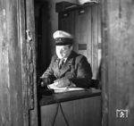 Der Aufsichtsbeamte in seinem damals noch kargen Dienstraum in Ludwigshafen Hbf. Zu dieser Zeit waren die Wiederaufbauarbeiten des Bahnhofs noch nicht abgeschlossen. Die Neueröffnung erfolgte im November 1954. Vielleicht wurde der Aufsicht bis dahin auch ein zeitgemäßer Dienstraum spendiert. (1952) <i>Foto: Werner Kortokraks</i>
