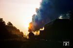 Eine 41er fährt auf der Strecke Oebisfelde - Stendal in die aufgehende Sonne des neuen Tages. Der Zug befindet sich auf der Fahrt nach Stendal und fährt in den Bahnhof Uchtspringe ein. Links der Lokomotive stehen die Ausfahrsignale von Uchtspringe in Richtung Oebisfelde, daneben das Stellwerk. Vor dem Stellwerk befindet sich der Bahnübergang der F 188. Dieser auf dem Foto gezeigte Strecken- und Straßenabschnitt wurde im Zuge des Baus der Neubaustrecke verlegt. (25.06.1978) <i>Foto: Dr. Uwe Knoblauch</i>
