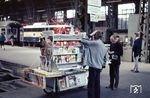 Ein fahrbarer Zeitungskiosk im Frankfurter Hauptbahnhof. Die aus heutiger Sicht eher bescheidene Auswahl scheint dennoch für Kopfzerbrechen zu sorgen. (1965) <i>Foto: Reinhold Palm</i>