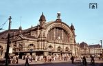 Frankfurt (Main) Hauptbahnhof ist mit täglich etwa 500.000 Reisenden nach dem Hamburger Hauptbahnhof der am zweitstärksten frequentierte Fernbahnhof in Deutschland. Der 1888 als „Centralbahnhof Frankfurt“ eröffnete Kopfbahnhof gehört zu den 21 Bahnhöfen der höchsten Preisklasse von DB Station&Service und zählt seit 2018 zur von DB Netz eingeführten Kategorie der Metropolbahnhöfe. Aufgrund seiner zentralen Lage bezeichnet ihn die Deutsche Bahn AG als wichtigste Verkehrsdrehscheibe im deutschen Zugverkehr. Das Bild zeigt den Haupteingang mit der 6 Meter hohen Bronze-Figurengruppe des Atlas auf der Hallenspitze, der die Weltkugel auf seinen Schultern trägt, begleitet von Symbolfiguren für Dampf und Elektrizität. (1961) <i>Foto: Reinhold Palm</i>