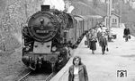 95 0005 ist mit P 18005 im Bahnhof Lauscha eingetroffen. Der Bahnhof wurde 1886 zunächst als Endpunkt der Steinachtalbahn durch die Werra-Eisenbahn-Gesellschaft errichtet. Das Bahnhofsgelände im engen Lauschatal am Fuß des Tierbergs wurde mit bis zu 10 m hohen Bruchsteinmauern zu dessen Hang hin gesichert. Das erste Empfangsgebäude stand in Längslage an der Bahnhofstraße. Im Zuge des Lückenschlusses zur Zoptetalbahn wurde er zum Spitzkehrenbahnhof umgebaut. Der Güterbereich wurde umfangreich erweitert. Hierzu wurde das abschüssige Gelände mit dem beim Bau des Lauschensteintunnels angefallenen Material aufgefüllt und mit einer Stützmauer aus 6000 m³ Stampfbeton gesichert. Zwischen 1912 und 1914 entstand das heutige, repräsentative Empfangsgebäude in Kopflage der beiden Gleise am Mittelbahnsteig. Das alte Empfangsgebäude wurde 1915 abgerissen und durch eine neue Güterabfertigung mit Büro- und Wohntrakt ersetzt. Ein Großteil der ehemals umfangreichen Gleisanlagen wurde 2001 stillgelegt. In Betrieb sind noch die beiden Bahnsteiggleise, ein Lokumfahrgleis und zwei kurze Abstellgleise.  (05.1977) <i>Foto: Burkhard Wollny</i>