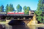 Gegen 6.40 Uhr morgens überquert DR 118 252 (Bw Halle P) mit dem D 303 nach München die Spree am Bahnhof Berlin-Bellevue in Richtung Westen und wird gleich den Bahnhof Zoo erreichen. Die Aufnahme entstand vom östlichen Ufer der Spree in der Lüneburger Str. und war so nur im Hochsommer möglich. (1976) <i>Foto: Karsten Risch</i>