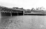 Blick über den Humboldt-Hafen auf die Stadtbahn. Vom Lehrter-Stadtbahnhof aus überspannt eine Stahlgitterbrücke den Hafen an der Spree. Am westlichen Ufer, von dem das Foto entstand, beginnt bereits Ost-Berlin. Der D 336 nach Hamburg hat mit 01 0532 kurz nach 16 Uhr den Bahnhof Friedrichstraße verlassen und befindet sich noch im Grenzgebiet. Der S-Bahnzug (links) fährt gerade aus dem S-Bahnhof Lehrter Bf aus. Im Hintergrund links sind die Dächer der Charité und rechts die Spitze des Fernsehturms zu sehen. Am 24. August 1961 kam hier Günter Litfin als erstes Todesopfer an der Berliner Mauer beim Durchschwimmen des Hafens durch Schüsse der DDR Grenztruppen ums Leben. (03.1975) <i>Foto: Karsten Risch</i>