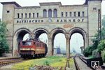 Der Bayerische Bahnhof in Leipzig wurde 1842 von der Sächsisch-Bayerischen Eisenbahn in Betrieb genommen und galt bis zu seiner Schließung im Jahr 2001 als der älteste in Betrieb befindliche Kopfbahnhof Deutschlands. Die Gleisanlagen wurden in den 2000er Jahren im Rahmen der Bauarbeiten für den City-Tunnel Leipzig vollständig abgebrochen. An ihre Stelle trat eine unterirdische Station, die im Dezember 2013 in Betrieb genommen wurde. Der stadtseitige Kopfbau („Portikus“) der früheren Bahnhofshalle, den gerade 242 025 durchfährt, blieb als Denkmal der Verkehrsgeschichte unter staatlichem Schutz stehen. Züge fahren dort allerdings nicht mehr hindurch.  (06.1980) <i>Foto: Joachim Claus</i>