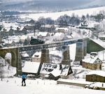 86 1001 rollt Lz über das Viadukt in Cranzahl nach Annaberg-Buchholz. Im Bahnhof Cranzahl startet gerade ein Schmalspurzug der Fichtelbergbahn nach Kurort Oberwiesenthal. (1986) <i>Foto: Joachim Schmidt</i>
