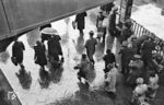 Reisende an einem regnerischen Frühjahrstag des Jahres 1938 in Berlin Anhalter Bf. Für 15 Pfennig werden auch die neuesten Nachrichten angeboten. Anfangs wurden Zeitungen überwiegend im Abonnement bezogen. Der Straßenverkauf wurde erst ab 1904 offiziell genehmigt. Bis zur Machtübernahme durch die Nazis konnte man 1932 in Berlin 966 (!) Zeitungen und Zeitschriften kaufen. Allein 147 Tageszeitungen erschienen in Berlin, manche davon sechs mal die Woche, andere sogar zwölf mal, wenn es eine Morgen- und Abendausgabe gab. Im Januar 1933 folgte die „Gleichschaltung“ der Presse, die eigentlich die Ausschaltung derselben war. Vielfalt und Pressefreiheit waren nur noch schöne Erinnerungen - eine Vorgehensweise, die heute totalitäre Staaten auf gleiche Weise anwenden. (04.1938) <i>Foto: RVM (Pragher)</i>