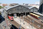 Zu Zeiten der deutschen Teilung war der Bahnhof Friedrichstraße eine der wichtigsten Grenzübergangsstellen zwischen Ost- und West-Berlin. Unmittelbar nach dem 13. August 1961, dem Tag des Berliner Mauerbaus, wurde der Bahnhof nach einer provisorisch organisierten Übergangsphase in mehrere Bereiche geteilt, die nach und nach durch Wände und Zwischendecken baulich streng getrennt wurden. Nach 1989 wurden die S-Bahn-Gleise am Bahnsteig C wieder für den durchgehenden Verkehr umgebaut, der bereits am 2. Juli 1990 aufgenommen werden konnte. Die zur DDR-Zeit errichteten Einbauten in die Bahnhofs- und Empfangshalle wurden genauso entfernt wie die zwischen beiden Bahnsteighallen eingezogene stählerne Sichtschutzwand. Im Jahr 2022, als sich hier eine S-Bahn und 182 023 vor RE 63970 nach Ostkreuz treffen, erinnert nichts mehr an die deutsche Teilung. (18.05.2022) <i>Foto: Benno Wiesmüller</i>