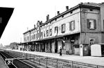 Aulendorfs Entwicklung wurde wesentlich von der Eisenbahn beeinflusst. Seit der Mitte des 19. Jahrhunderts entfaltete es sich zu einer Eisenbahnstadt. Mit Eröffnung der Teilstrecke Biberach an der Riß – Ravensburg der Württembergischen Südbahn kam am 26. Mai 1849 die Eisenbahn nach Aulendorf. Mit Eröffnung der Teilstrecke Saulgau – Waldsee am 25. Juli 1869 wurde der Ort schließlich zum wichtigsten Knotenbahnhof in Oberschwaben. Der Eisenbahnbau in Zeiten großen wirtschaftlichen Elends bewahrte auch im ländlichen Aulendorf viele Menschen vor Hunger oder Auswanderung. Die Bahn und die Post waren damals die größten Arbeitgeber in Aulendorf. Zeugen davon sind die im Vorfeld des Bahnhofs in der Bahnhofstraße gelegenen großen Wohnhäuser aus dieser Zeit. Das Empfangsgebäude, das hier noch deutliche Spuren des Krieges zeigt, stammt ebenfalls aus der Frühzeit der Württembergischen Südbahn. (11.07.1959) <i>Foto: Karl-Ernst Maedel</i>