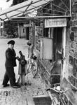 Im Bahnhof Reisen (Hess) war der Bedienstete im sog. Gemeinschaftsdienst sowohl für betriebliche (Fahrdienstleiter, Schrankenwärter) als auch für verkehrliche Aufgaben (Fahrkartenaufgabe, Gepäckabfertigung) zuständig. Dabei hatte die betriebliche Abfertigung von Zügen immer Vorrang. (1955) <i>Foto: Kopetzky</i>