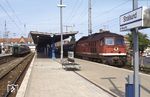 1977 und 1978 wurden von der DR sechs Lokomotiven mit einer Motorleistung von 4000?PS und einer Höchstgeschwindigkeit von 120 km/h als Baureihe 142 in Dienst gestellt. Eingesetzt wurden die Loks im schweren Güterverkehr auf den nicht elektrifizierten Strecken im Norden der DDR. Zu den fast nur der Baureihe 142 vorbehaltenen Bespannungsaufgaben gehörten die schweren Kesselwagenzüge mit bis zu 3600?t Zuglast zwischen dem Ölhafen Rostock und dem Petrolchemischen Kombinat Schwedt. Das Bw Stralsund setzte die 142 als Ablösung der Baureihe 03.10 auch vor schweren Urlauberzügen ein, um Fahrzeitverlusten infolge ungenügender Beschleunigungswerte vorzubeugen. Inzwischen wurde auf politischer Ebene aber die Entscheidung getroffen, die wichtigsten Hauptstrecken auch im Norden zu elektrifizieren, so dass man auf weitere Bestellungen der Baureihe 142 verzichtete. Durch die Wende und die verbundenen Begleitumstände sanken die Leistungen im schweren Güterzugdienst erheblich, was die Baureihe 142 als Splitterbaureihe schließlich überflüssig machte. Die 1992 in 242 001 umgezeichnete 142 001 steht hier vor einem Reisezug im Bahnhof Stralsund. 1995 wurde sie ausgemustert und verkauft. (08.1992) <i>Foto: Klaus Hof</i>