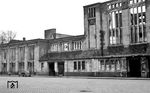 Die Reste des einst stattlichen Empfangsgebäude des Bahnhofs Köln-Mülheim. Der bereits 1874 eröffnete Bahnhof wurde von 1903 bis 1909 komplett neu gestaltet und der gesamte Güter- und Personenverkehr über die zusammengeführten Strecken der CME und BME zusammengelegt. In diesem Zusammenhang entstand ein großes Empfangsgebäude im klassizistischen Stil. Der Bahnhof hieß damals noch Mülheim am Rhein, da Mülheim erst 1914 nach Köln eingemeindet wurde und zur damaligen Zeit eine selbständige Stadt war. Dies erklärt auch die für einen Vorortbahnhof großzügig dimensionierten Anlagen und Gebäude. Bei einem Fliegerangriff am 28. Oktober 1944 brannte das Bahnhofsgebäude vollständig aus. Die Ruine wurde Mitte der 1950er Jahre abgerissen und durch einen schmucklosen Zweckbau ersetzt. (1953) <i>Foto: Karl Wyrsch, Slg. D. Ammann</i>