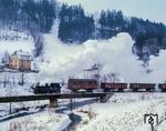 99 1561 überquert mit einem Rollwagengüterzug die Preßnitz bei Streckewalde. Nachdem der Personenverkehr am 30. September 1984 eingestellt worden war, bekam der Güterverkehr noch eine Galgenfrist, da für das Kühlschrankwerk in Niederschmiedeberg erst die nötigen Voraussetzungen für den endgültigen Verkehrsträgerwechsel geschaffen werden mussten. Die Gesamtstilllegung der Strecke erfolgte dann am 31. Dezember 1986. (07.01.1986) <i>Foto: Joachim Schmidt</i>
