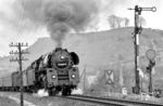 01 0505 hat mit dem P 8015 nach Saalfeld (Saale) soeben den Bahnhof Krölpa-Ranis verlassen. Die hohe Kilometrierung rechnet sich von Leipzig Hbf (km 0,0) bis zur Landesgrenze Thüringen – Bayern bei Probstzella (km 166,666). Auch das Einfahrsignal 'F' des Bahnhofs ist einen Hinweis wert, weil der obere Signalflügel anstelle einer vollständigen Blende mit zwei Öffnungen (rot - grün) die Rot-Blende mit einer viereckigen Öffnung im Flügel selbst aufweist, während die Grün-Blende offenbar mit einem halben Blendenträger unterhalb montiert zu sein scheint. Möglicherweise handelt es sich um ein früheres Länderbahn-Signal, bei dem die Blenden nicht getrennt (wie bei den Reichsbahn-Signalen) sondern in fester Verbindung mit dem Signalflügel bewegt wurden. (05.1980) <i>Foto: Karsten Risch</i>