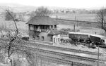 Blick auf das Wärterstellwerk "Ewn" im Bahnhof Eschwege West. Das Stellwerk wurde 1973 abgerissen. Der Bahnübergang ist auch verschwunden, die Bundesstraße 27 wurde komplett auf die Seite des Fotografens verlegt. Im Hintergrund verläuft das Streckengleis nach Eschwege Stadt. (01.05.1958) <i>Foto: Winfried Gronwald</i>