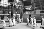 Reger Reisendenverkehr auf dem Bahnsteig Gleis 12/13 in Frankfurt/M Hbf mit einer V 200 des Bw Frankfurt-Griesheim. Diese ist mit dem D 74 aus Hamburg-Altona angekommen.  (03.1960) <i>Foto: Winfried Gronwald</i>