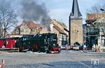 99 7239 fährt mit P 14453 an Wernigeroder Altstadt vorbei. Ihr Wahrzeichen ist der mittelalterliche Wehrturm aus massivem Mauerwerk. Das 41 Meter hohe Bauwerk ist das letzte verbliebene Relikt der alten Stadtverteidigungsanlagen. (22.02.1990) <i>Foto: Wolfgang Bügel</i>