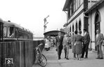 Um Friedrichsdorf und die Taunusgemeinden an den Frankfurter Eisenbahnverkehr anzubinden, begann 1895 der Bau der Usinger Bahn. Sie führte eingleisig vom Usinger Bahnhof in Bad Homburg über Seulberg nach Friedrichsdorf und weiter über Köppern in den Taunus. Mit deren Bau erhielt Friedrichsdorf den Durchgangsbahnhof. Die Usinger Bahn wäre jedoch nicht die einzige Möglichkeit eines Bahnanschlusses für Friedrichsdorf gewesen; schon vorher liefen Planungen für eine Querverbindung zur Main-Weser-Bahn. Erst 1901 wurde die Strecke Friedberg–Friedrichsdorf in Betrieb genommen. Ein Empfangsgebäude im klassizistischen Stil entstand westlich der Gleise und steht heute unter Denkmalschutz. Von der Fußgängerbrücke im Hintergrund sind heute nur noch die Fundamente zu finden. Ein Schienenbus erhält gerade Ausfahrt auf Gleis 1 in Richtung Bad Homburg. (06.1961) <i>Foto: Winfried Gronwald</i>