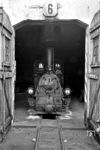 99 3352 im Friedländer Schuppen. Für die Mecklenburg-Pommerschen Schmalspurbahn AG (MPSB) wurden von 1906 bis 1913 von der Arnold Jung Lokomotivfabrik sieben Lokomotiven der Bauart C1’ n2t hergestellt. Nach dem Ende des Zweiten Weltkrieges mussten die Lokomotiven 2, 3, 6 und 7 der MPSB als Reparation an die Sowjetunion abgegeben werden. 1949 wurde die Mecklenburgisch-Pommersche Schmalspurbahn von der Deutschen Reichsbahn übernommen. Entsprechend dem Nummernschema wurden die Lokomotiven 1, 4 und 5 in die Baureihe 99.335 eingeordnet. Lok 4 erhielt die Betriebsnummer 99 3352. Die Deutsche Reichsbahn rüstete die Lok mit einem Turbogenerator für die elektrische Beleuchtung nach. Ebenso besaß sie zur Erweiterung der Reichweite einen zweiachsigen, durch die MPSB selbst hergestellten, Wassertender.  (07.1967) <i>Foto: Klaus Kieper, Slg. Holzborn</i>