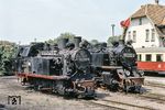 Im Ostseebad Kühlungsborn West warten 99 2331 und 99 2322. Gut zu erkennen sind die Bauartunterschiede der beiden Loks. 99 2331 des Typs 225 PS Schmalspur des VEB Lokomotivbau Karl Marx basiert auf einem Typenprogramm für kleinere Dampflokomotiven, die speziell für den Einsatz bei Industriebetrieben entwickelt wurden. Ende der 1950er Jahre sah sich die Reichsbahn veranlasst, die 27 Jahre alten Lokomotiven der Baureihe 99.31 zu ersetzen. Ein Nachbau der Baureihe 99.32 war nicht möglich. So erwarb die Reichsbahn drei Lokomotiven von der SDAG Wismut. Im April 1959 wurde 99 331 (ehemals Nr. 22) nach Anpassungsarbeiten im Raw Görlitz in Dienst gestellt. 1961 wurden sie auf Heißdampf umgebaut. 99 2322 hingegen wurde 1932 nach den Einheitsgrundsätzen der Deutschen Reichsbahn gebaut und ist auch bis heute bei der "Molli" im Einsatz. (06.1979) <i>Foto: Robin Fell</i>