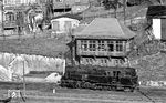 95 0005 vor dem mechanischen Stellwerk in Lauscha (Thür), das 1913 nach Plänen der Ingenieure Jacobi und Steinbrinck gebaut wurde. Das dreigeschossige Gebäude wurde in die Stützmauer am Bahnweg integriert. Der Bedienraum im obersten Stockwerk ist durch eine regionaltypische verschieferte Fachwerkfassade gekennzeichnet, die weit auskragt und große Fenster zur Außenbeobachtung (Fahrwegprüfung) hat. Am 22.01.1997 wurde es außer Betrieb genommen. (04.1977) <i>Foto: Burkhard Wollny</i>