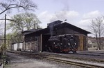 099 754 vor dem Lokschuppen in Radeburg, dem Endpunkt der Schmalspurbahn von Radebeul-Ost. Mit Gründung der Deutschen Bahn AG am 1. Januar 1994 strebte der neue Eigentümer schnellstmöglich eine Stilllegung, bestenfalls eine Privatisierung, der Strecke an. Dampflokomotiven passten nicht in das "moderne" Image der neuen Bahn. Am 11. Juni 2004 ging die Strecke schließlich an die in Annaberg-Buchholz ansässige BVO Bahn GmbH (heute: Sächsische Dampfeisenbahngesellschaft) über.  (04.1992) <i>Foto: Will A. Reed</i>